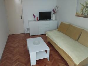 ein Wohnzimmer mit einem Sofa und einem Tisch in der Unterkunft Apartments Piko2 in Jelsa