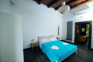 ein Schlafzimmer mit einem blauen Bett in einem Zimmer in der Unterkunft Domus Gisulfo in Salerno