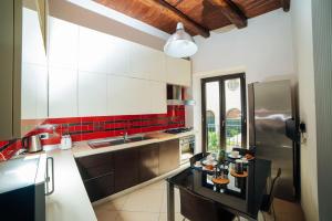 eine Küche mit einem Kühlschrank aus Edelstahl und roten Fliesen in der Unterkunft Domus Gisulfo in Salerno