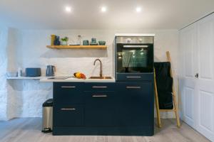a kitchen with blue cabinets and a sink at Island Studio with on-site parking in St Ives
