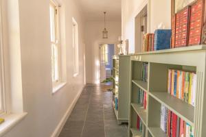 a hallway with bookshelves filled with books at Huckleberry House - La Bruyere Farm in Tulbagh