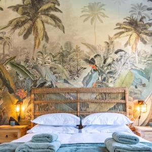 a bedroom with a mural of palm trees at Huckleberry House - La Bruyere Farm in Tulbagh