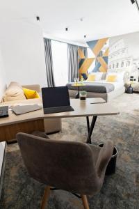 a living room with a table with a laptop on it at MM Boutique Hotel in Burgas