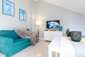 a living room with a blue couch and a tv at Collection CityLife Suites with Terrace - Top Collection in Milan