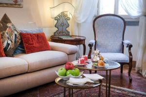 a living room with a couch and a table with fruit on it at Relais & Châteaux Il Falconiere in Cortona