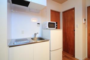 a kitchen with a sink and a microwave and a refrigerator at 柏・二条1（Haku Nijo1） in Kyoto +12 photos