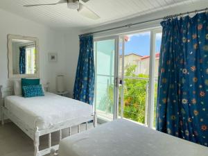 a bedroom with two beds and a large window at Villa 238A Jolly Harbour in Jolly Harbour