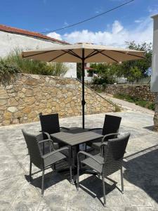 a table and chairs under an umbrella on a patio at Modern & Cozy Studio in Koroni