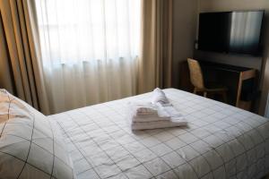 VILLA MANZONI في كولونيو أل سيريو: غرفة فندق عليها سرير وفوط