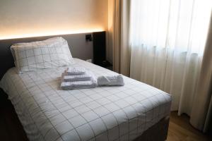 uma cama com lençóis brancos e toalhas em VILLA MANZONI em Cologno al Serio