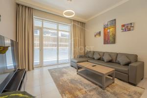 杜拜的住宿－KeyHost - Spacious 1BR with Parking near Five hotel in JVC - Dubai - KG10，客厅配有沙发和桌子