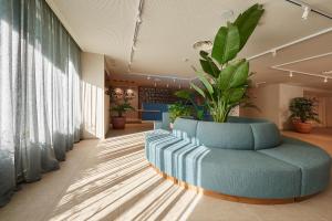 un vestíbulo con un sofá azul y una maceta en Palmasol, en Benalmádena