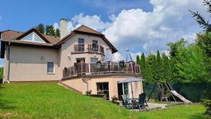 ein großes Haus mit einem Balkon und einem Spielplatz in der Unterkunft Villa Vranov 55 in Čerčany