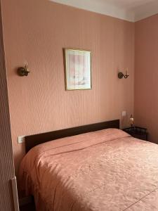 um quarto com uma cama e uma fotografia na parede em La renaissance em Saint-Cirgues-en-Montagne