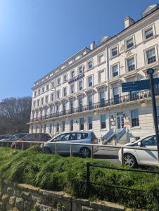 un grand bâtiment blanc avec des voitures garées devant lui dans l'établissement Bike & Boot Inns Scarborough - Leisure Hotels for Now, à Scarborough