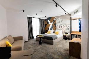a hotel room with a bed and a couch at MM Boutique Hotel in Burgas