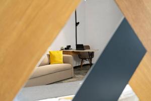 a room with a couch and a table with a yellow pillow at MM Boutique Hotel in Burgas