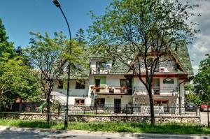 a large white house with a green roof at Willa Karpinskich in Zakopane