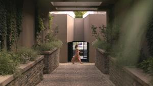 a woman walking through an alley in a building at Vaya Beach Resort in Emona