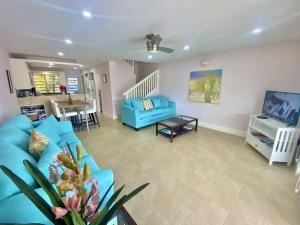 a living room with a blue couch and a table at Villa 218G Jolly Harbour in Jolly Harbour