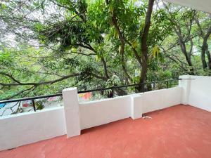 a white balcony with trees in the background at BedChambers Serviced Apartments, Hyderabad in Hyderabad