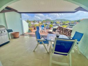 a patio with chairs and a table and a balcony at Villa 218G Jolly Harbour in Jolly Harbour