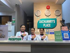 Tres chicas detrás de un mostrador con sus certificados en Dachannry's Place Hotel en Cagayán de Oro