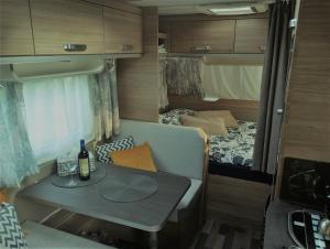um pequeno quarto com uma mesa e uma cama num trailer em Galéria šťastia DS, balneológia em Dunajská Streda