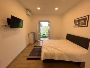 um quarto com uma cama e uma televisão de ecrã plano em BikeandClimb B&B em Finale Ligure