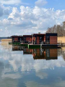 a house on a dock on a body of water at "D" Domki na wodzie Barczewko 4 z 4 domków in Barczewko