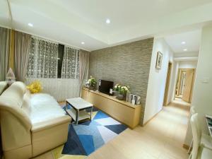 a living room with a couch and a television at Happy valley apartment 1000sp香港跑馬地最中心地帶3房一套+工人房奢華装修公寓， in Hong Kong