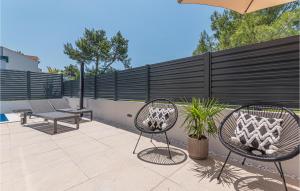 a patio with two chairs and a fence at Cozy Home In Srima With Wifi in Srima