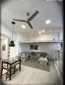 een woonkamer met een plafondventilator en een tafel bij Sweet house in Sant Feliu de Guixols