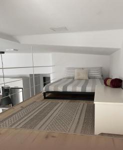 een witte slaapkamer met een bed en een tapijt bij Sweet house in Sant Feliu de Guixols