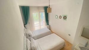 Habitación pequeña con muebles blancos y ventana. en Pervin Hanım Konağı, en Alacati