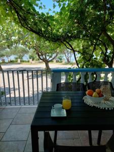 een zwarte tafel met een fruitschaal en een glas sinaasappelsap bij Apartman Lucija in Seline