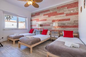 a bedroom with two beds and a brick wall at Mom's House - Surf & Family by LovelyStay in Costa da Caparica