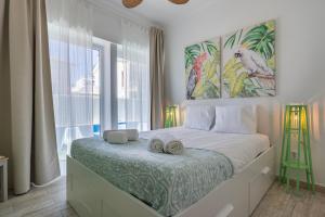 a bedroom with a bed with two towels on it at Mom's House - Surf & Family by LovelyStay in Costa da Caparica