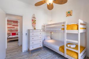 a bedroom with two bunk beds and a ceiling fan at Mom's House - Surf & Family by LovelyStay in Costa da Caparica