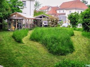 um jardim com relva alta em frente a uma casa em Hotel PrimaVera parco em Fürth