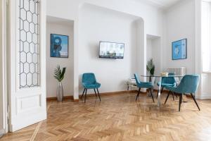 a dining room with a table and blue chairs at Collection Duomo Suite 2 - Top Collection in Milan