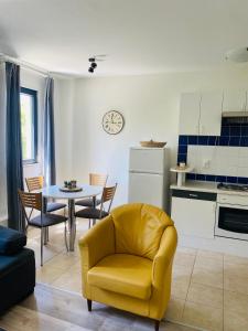 ein Wohnzimmer mit einem gelben Stuhl und einem Tisch in der Unterkunft Karina Apartments in Supetar