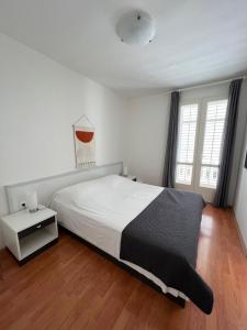 a bedroom with a large bed with a black blanket at Karina Apartments in Supetar