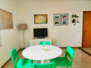 Habitación con mesa blanca y sillas verdes. en Il Mare di Giò, en Monopoli