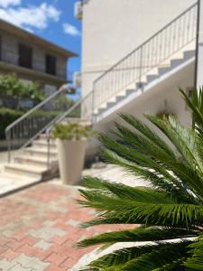 uma escada que leva a um edifício com uma palmeira em Karina Apartments em Supetar