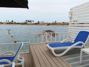 a deck with two chairs and a table on the water at Sea Gull Marina Hotel in El Alamein