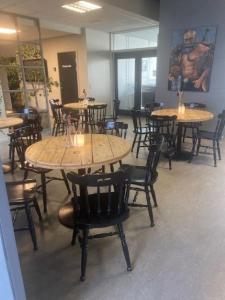 Danhostel Thorhallen Jels في Jels: غرفة طعام مع طاولات وكراسي في مطعم