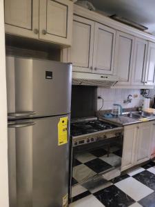 a kitchen with white cabinets and a stainless steel refrigerator at Serine Hostel in Alexandria