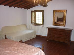 a bedroom with two beds and a mirror and a dresser at La Valle dei Gobbi in Monsummano Terme