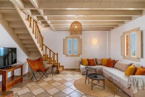 a living room with a couch and a tv at Vacay Suites in Firostefani